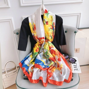 Elegant red floral silk scarf with artistic print styled on a mannequin in a chic room