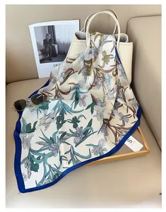 Detail of iris print silk scarf draped over a beige handbag for stylish accessory display
