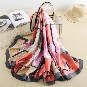 Detailed view of square silk scarf with horse print on white handbag with soft textures