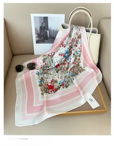 Gros plan d'un foulard en soie à imprimé floral noué sur un sac à main blanc élégant