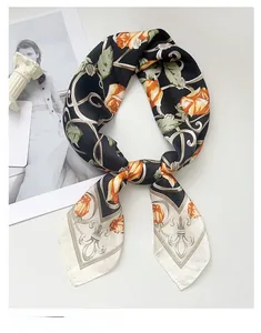 Détail d'un élégant foulard en soie noire avec des roses orange et des motifs vintage