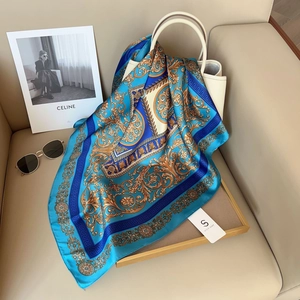 Foulard en soie bleu et or de style britannique élégamment drapé sur un sac à main