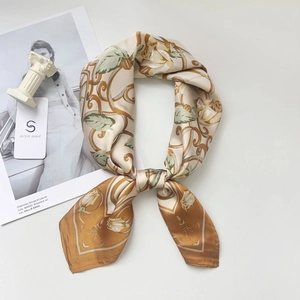 Détail d'un foulard élégant en soie à motifs floraux avec étiquette de marque et décor