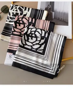 Close-up of elegant camellia print silk scarves in black and pink with smooth texture