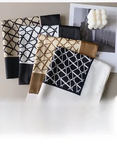 Detail of four silk-like satin scarves with geometric chain patterns and luxury tags