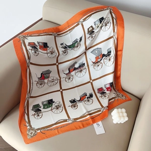 Detail of a white silk scarf with orange borders featuring classic vintage horse carriage prints