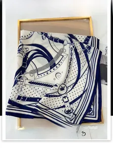 Detail view of chain print square scarf with gold frame and brand tag decor