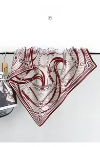 Detailed view of chain print silk scarf in burgundy and cream hung on a black rod