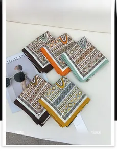 Flat lay of small herringbone printed scarves in multiple colors with luxury accessories