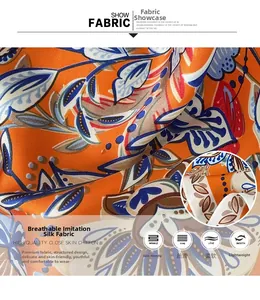 Close-up of soft breathable faux silk scarf fabric with orange and blue leaf patterns