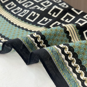 Detailed view of silk-like neck scarf with geometric patterns and floral print edges