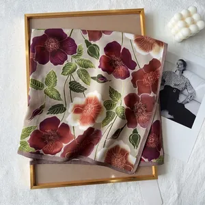 Detail of elegant herringbone square scarf with purple floral print on beige fabric