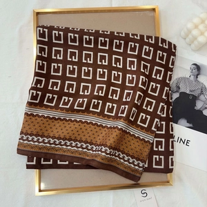 Detail view of a vintage geometric pattern scarf with silk texture in brown and white