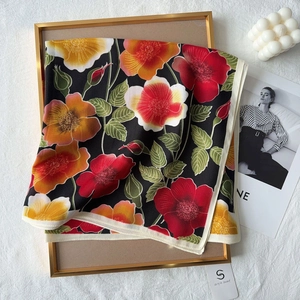 Detail of floral printed cotton feel scarf with vibrant red flowers on black background