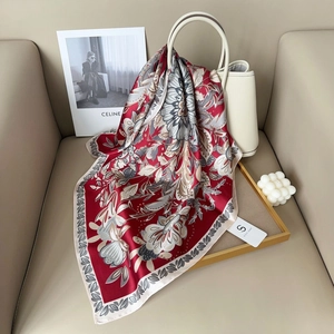 Elegant 70cm vintage red floral silk-like scarf draped on a beige handbag with artistic props