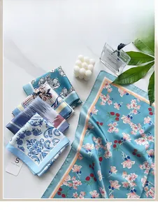 Macro view of a 58cm floral silk scarf with elegant oil painting prints and a brand tag