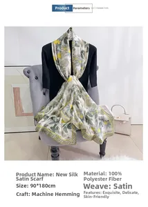 Detail showing high-quality satin silk scarf with large yellow floral prints and machine hem