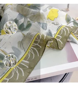 Detailed macro view showing the floral chiffon fabric texture and yellow hem of the scarf