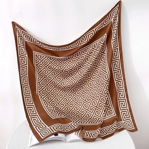 Detail of a brown and white silk scarf with geometric pattern and satin texture
