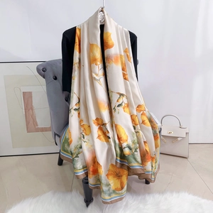 Dettaglio macro di un grande foulard in seta a fiori con eleganti bordi colorati