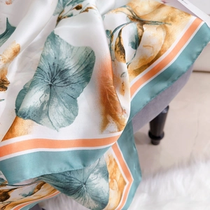 Elegante foulard in seta con fiori gialli e foglie verdi su sfondo color crema