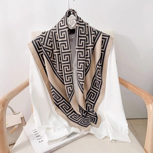 Classic Greek key pattern square silk scarf in black and brown over a white shirt