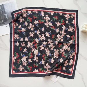Detailed view of square silk scarf with floral pattern on marble background