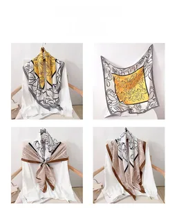 Detail of floral print silk square scarves in yellow and beige with contrast borders
