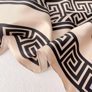 Detail of silk texture scarf with beige base and black Greek key geometric pattern