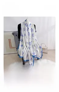 Detail eines eleganten weißen Satinschals mit lila Tulpenprint und blauen Rändern