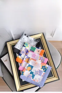 Gros plan détaillé de foulards en soie synthétique pliés avec divers motifs floraux colorés