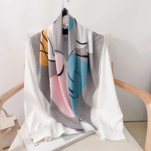 Summer square silk scarf with geometric colorful prints draped on a white shirt