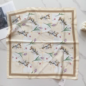 Detail view of satin square scarf with purple tulip floral print on marble background