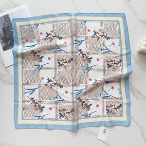 Flat lay detail of 58cm silk scarf with floral tulip patterns and blue geometric borders