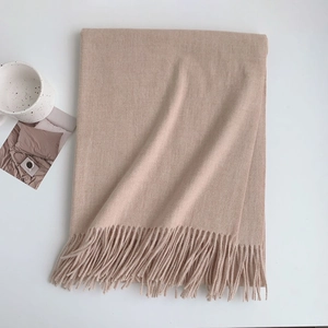 Thick beige faux cashmere scarf with tassels in a minimalist lifestyle setting