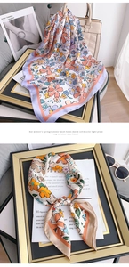 Detailed view of floral silk scarves with elegant watercolor prints and glossy texture