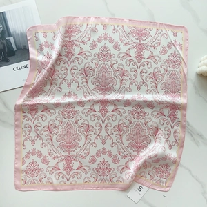 Detail view of a 58cm silk scarf with pink baroque floral patterns on marble