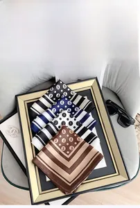 Close-up of imitation silk square scarves featuring polka dots and stripes in a tray