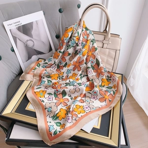 Elegant floral silk square scarf tied to a beige tote bag for a high-end lifestyle look