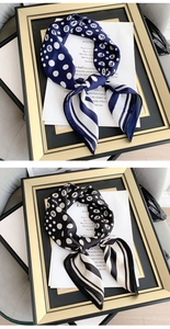 Close-up of silk scarves with polka dots and stripes displayed in elegant gold frames