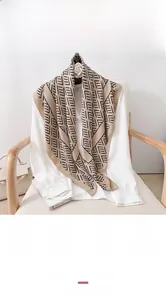Detail of elegant geometric print silk scarf draped over a white professional shirt