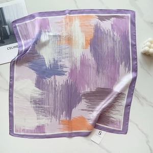 Close-up of artistic silk-like square scarf with purple abstract stripes on marble