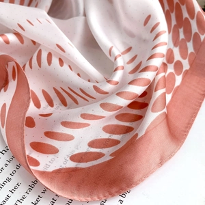 Silk-like square scarf with orange polka dots and geometric patterns on ivory fabric