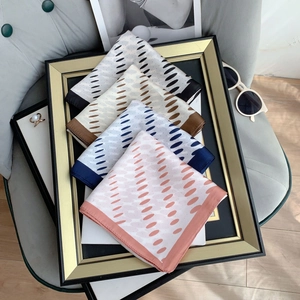 Polka dot silk square scarves in four colors elegantly displayed on a vintage gold frame