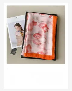 Dettaglio di sciarpa in seta rosa con stampe floreali rosse e bordi cuciti a contrasto