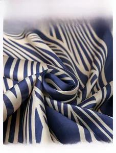 Detailed macro view of the silky texture and navy blue striped print on the scarf