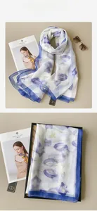 Dettaglio della sciarpa di seta con grandi fiori blu ed eleganti bordi blu navy