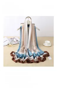 Detail view of a luxury silk satin scarf with geometric patterns on a stylish hanger