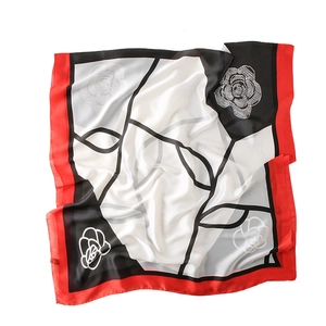 Elegant red black and white camellia pattern square silk scarf in a flat lay display