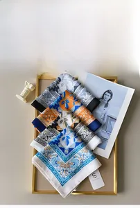 Close-up of assorted vintage floral silk scarves layered in a golden decorative tray